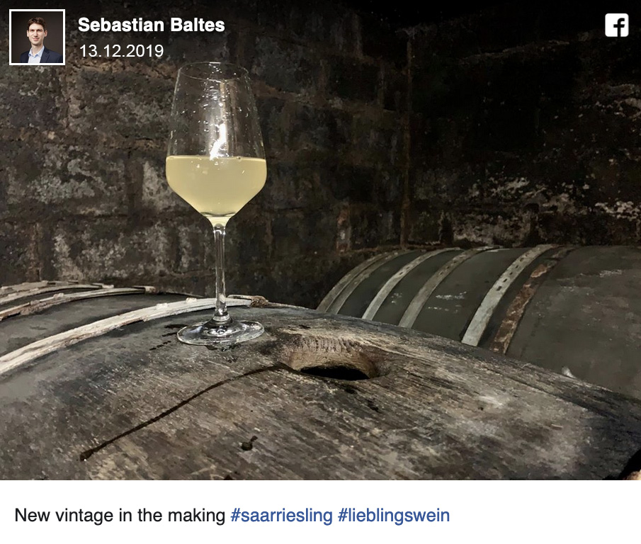 Facebook-Beitrag vom 13.12.2019: Glas Jungwein auf einem Holzfass im Keller